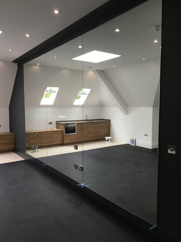 Frameless glass partition in loft conversion by Kensal Green glaziers