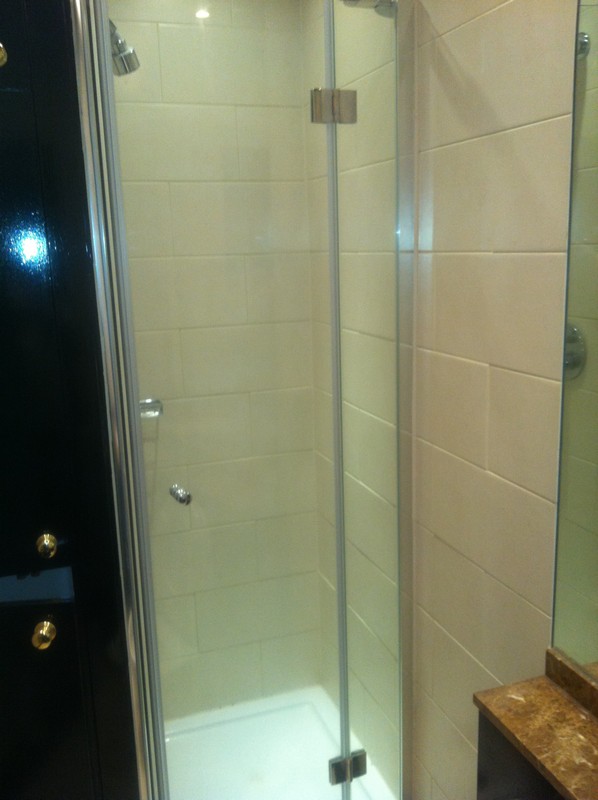Frameless glass shower enclosure with chrome fittings in Kensal Green